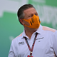 McLaren CEO Zak Brown wearing an orange face mask.